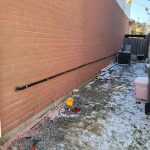 run wire along exterior brick wall